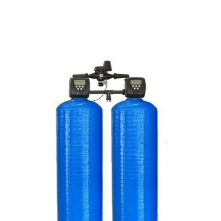 Zwei blaue Zylindertanks mit schwarzen Steuerungseinheiten und Rohrleitungen in industrieller Umgebung.